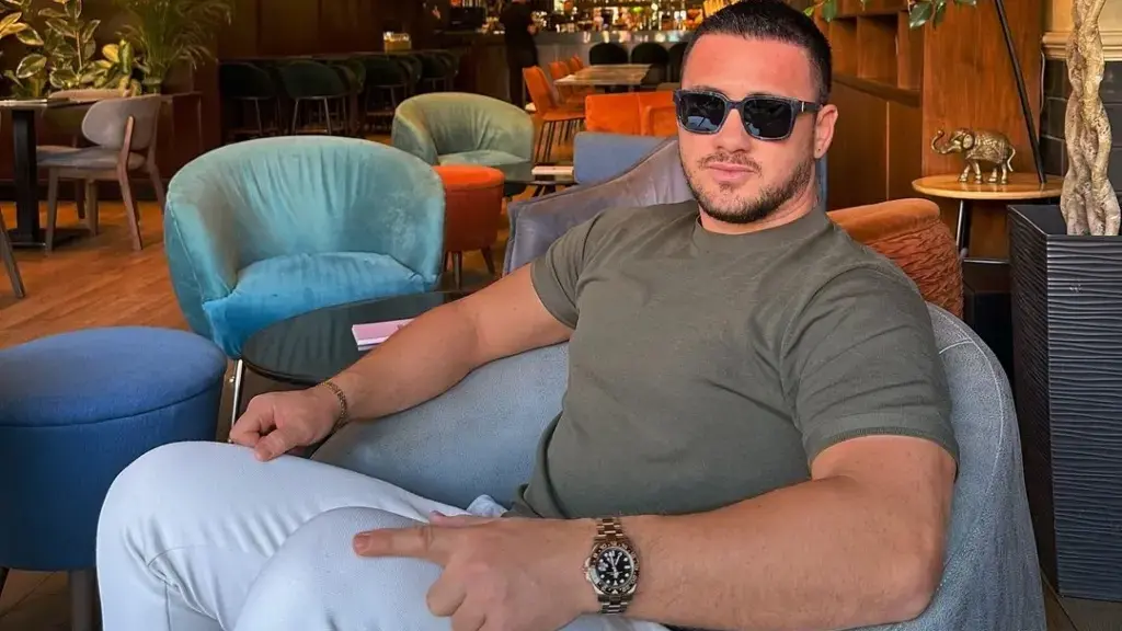 Albatrit Muqiqi pozon pranë vetures së tij super luksoze